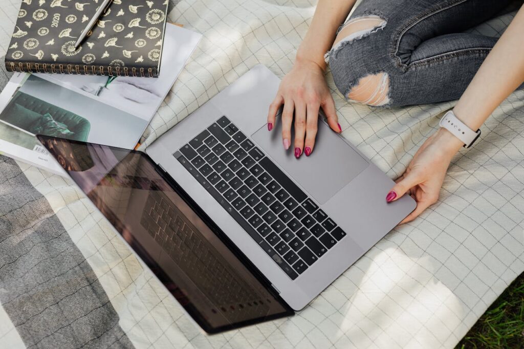 Crop college student using laptop in park